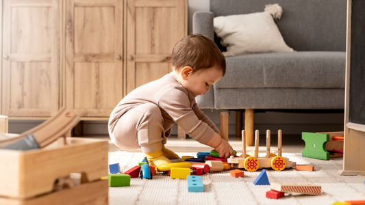 A baby playing with a range of different wooden toys.