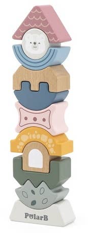 A wooden block tower toy puzzle made by PolarB, featuring uniquely shaped and brightly colored pieces stacked vertically. The blocks include various geometric and abstract shapes, such as arches, waves, and a triangle at the top with a smiling bear face. The base of the tower is labeled ‘PolarB.