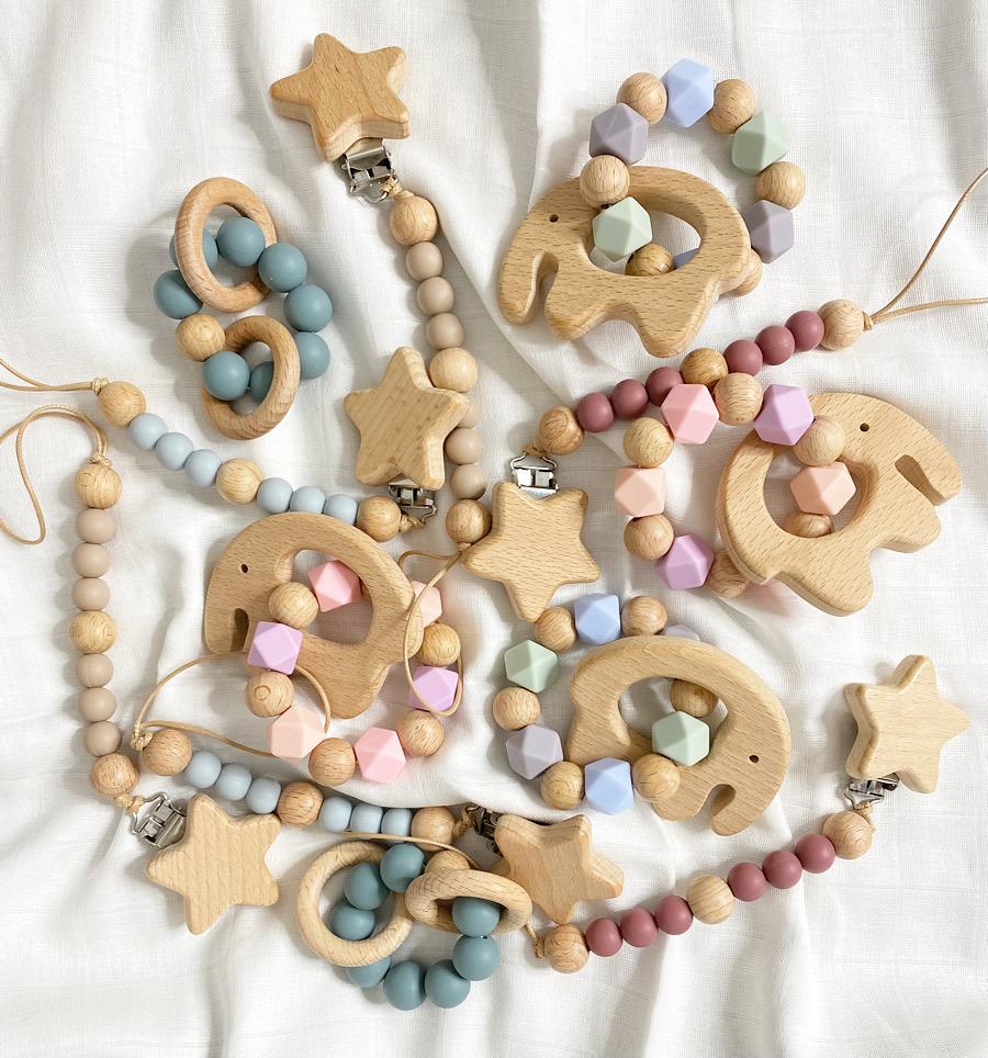 A collection of wooden toys featuring stars and hearts, alongside baby teether toys and dummy clips.